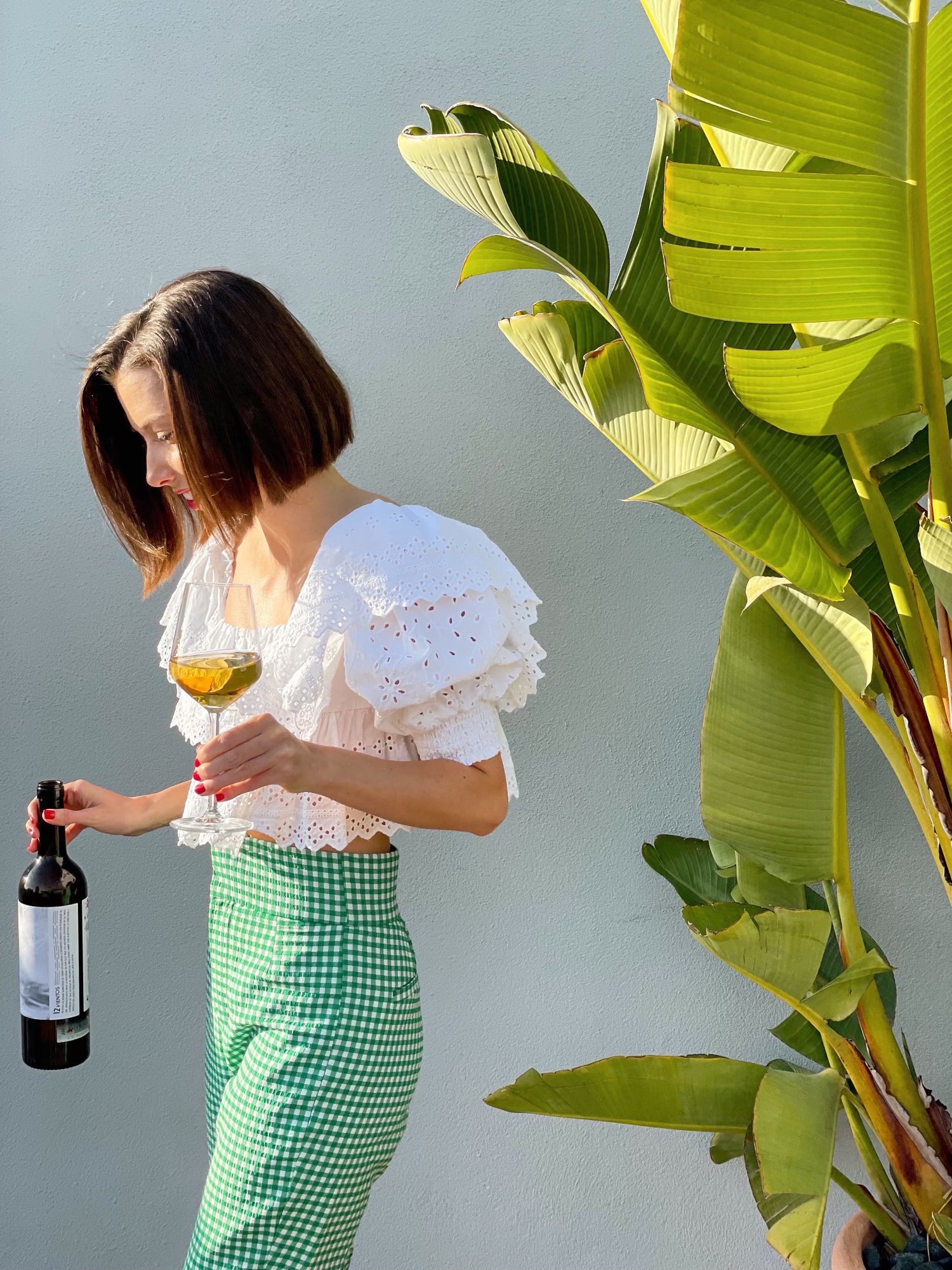 girl holding white wine with plants